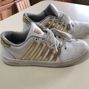 K-Swiss tennis shoes with gold details.